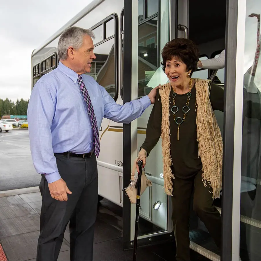NorthRidge man helping lady off bus